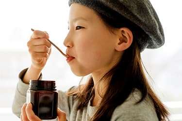 493ss_getty_rf_young_girl_eating_manuka_honey_from_jar.jpg?resize=375px:250px&output-quality=50